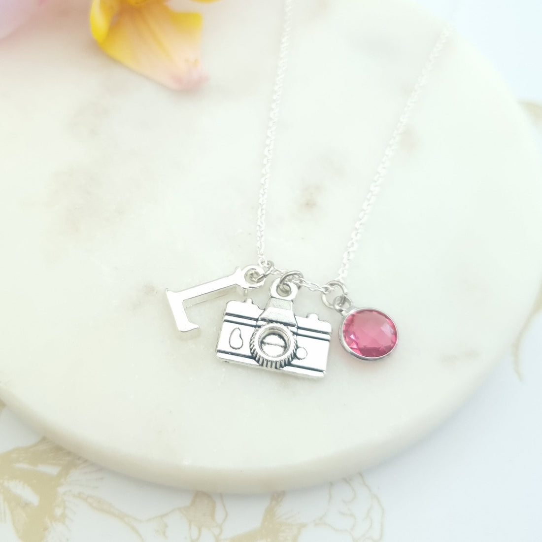 sterling silver necklace with camera charm, an initial and a birthstone in a gift box