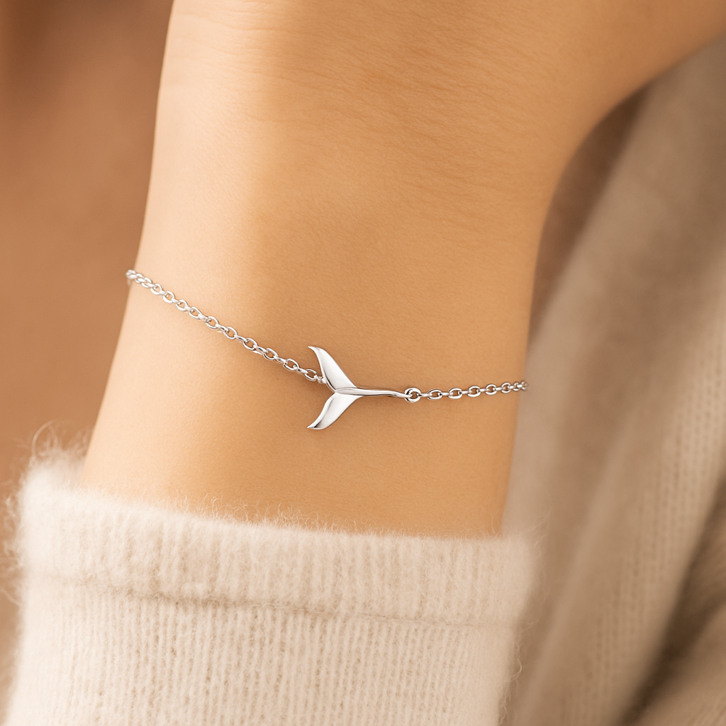 Sterling silver whale tail bracelet on a delicate adjustable chain, displayed on a white background.