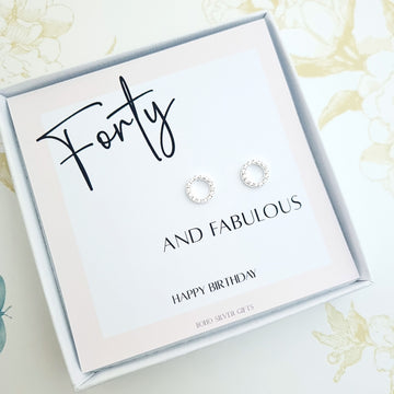 a pair of sterling silver circle stud earrings in a gift box with a card saying forty and fabulous