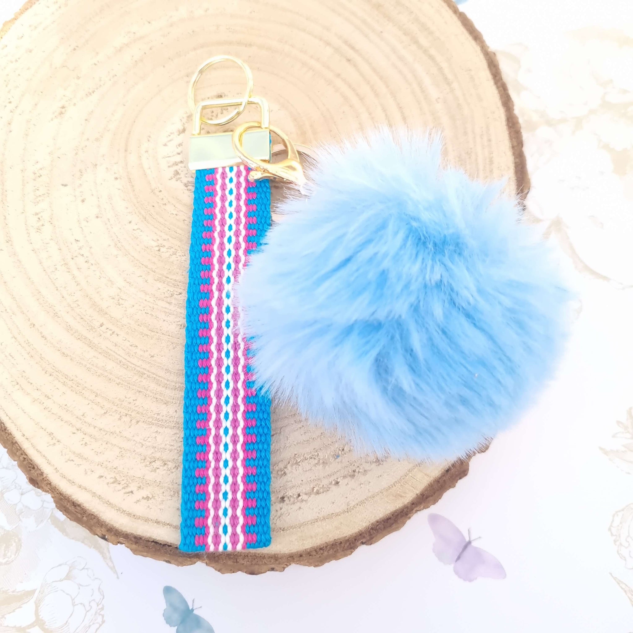 a handmade bracelet key ring in blue with pompom
