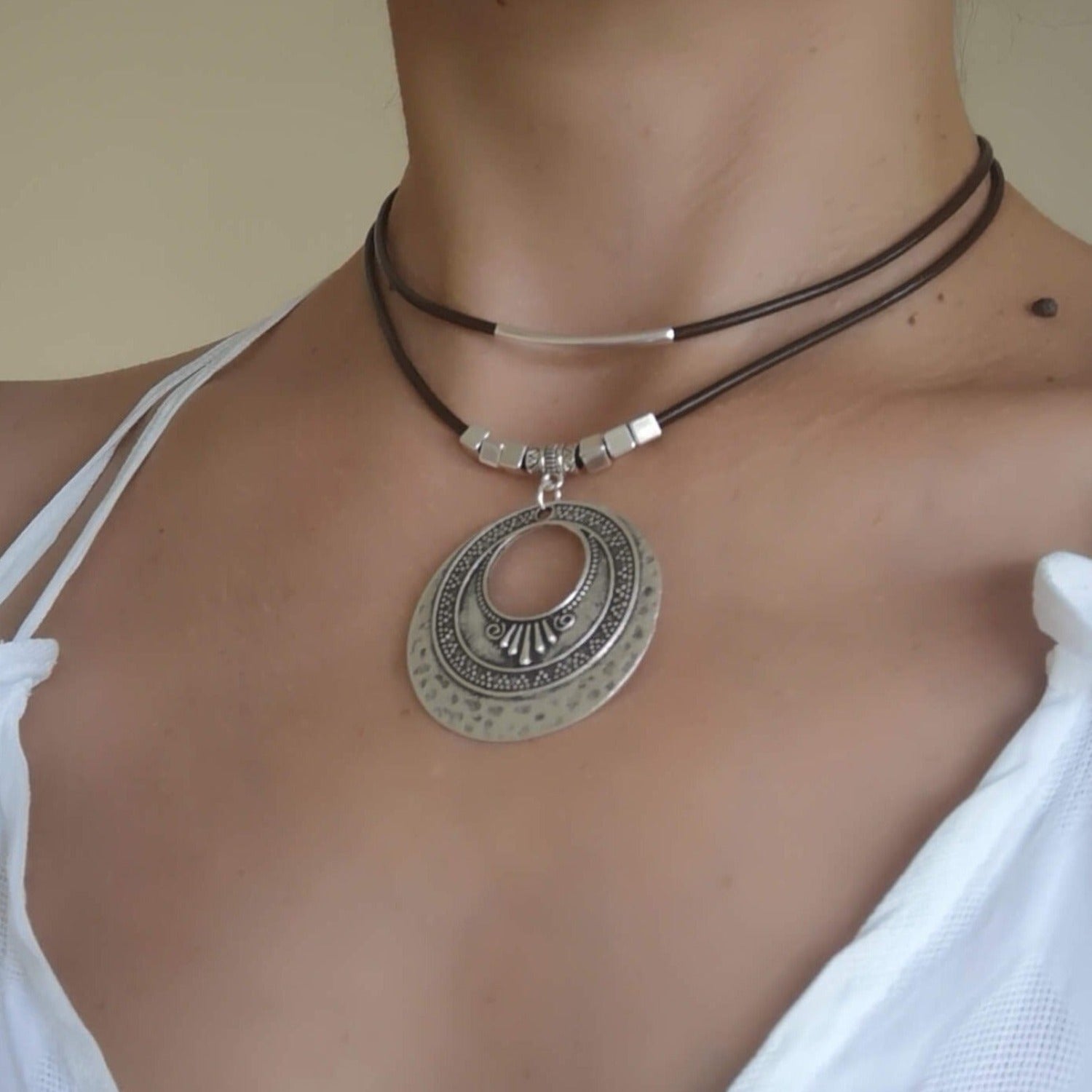 a boho leather necklace with a medallion