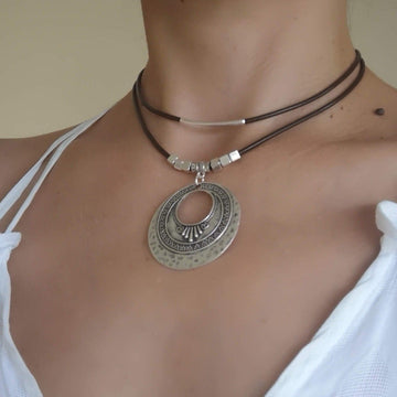 a boho leather necklace with a medallion