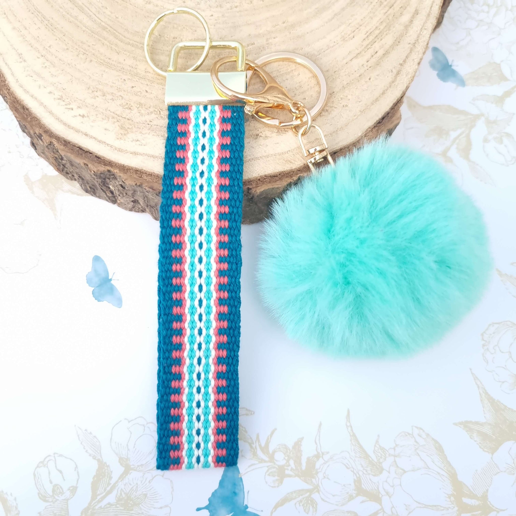 wrist lanyard in teal and green with pom pom