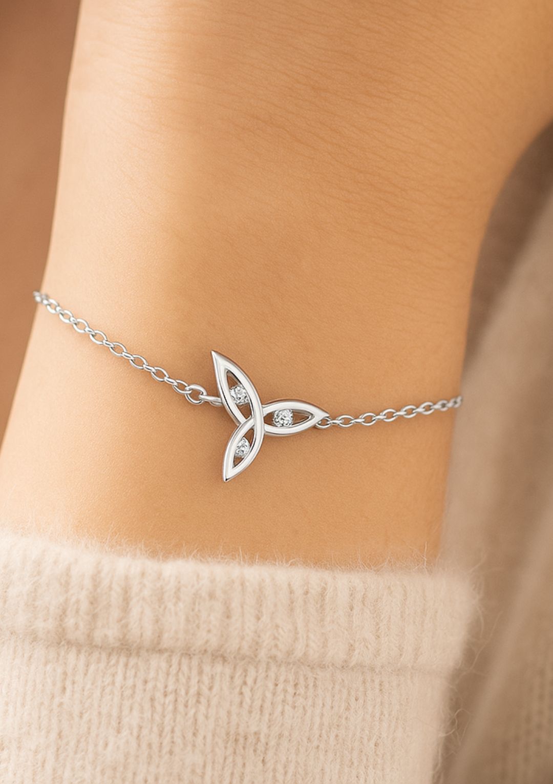 a wrist wearing a triquetra sterling silver bracelet