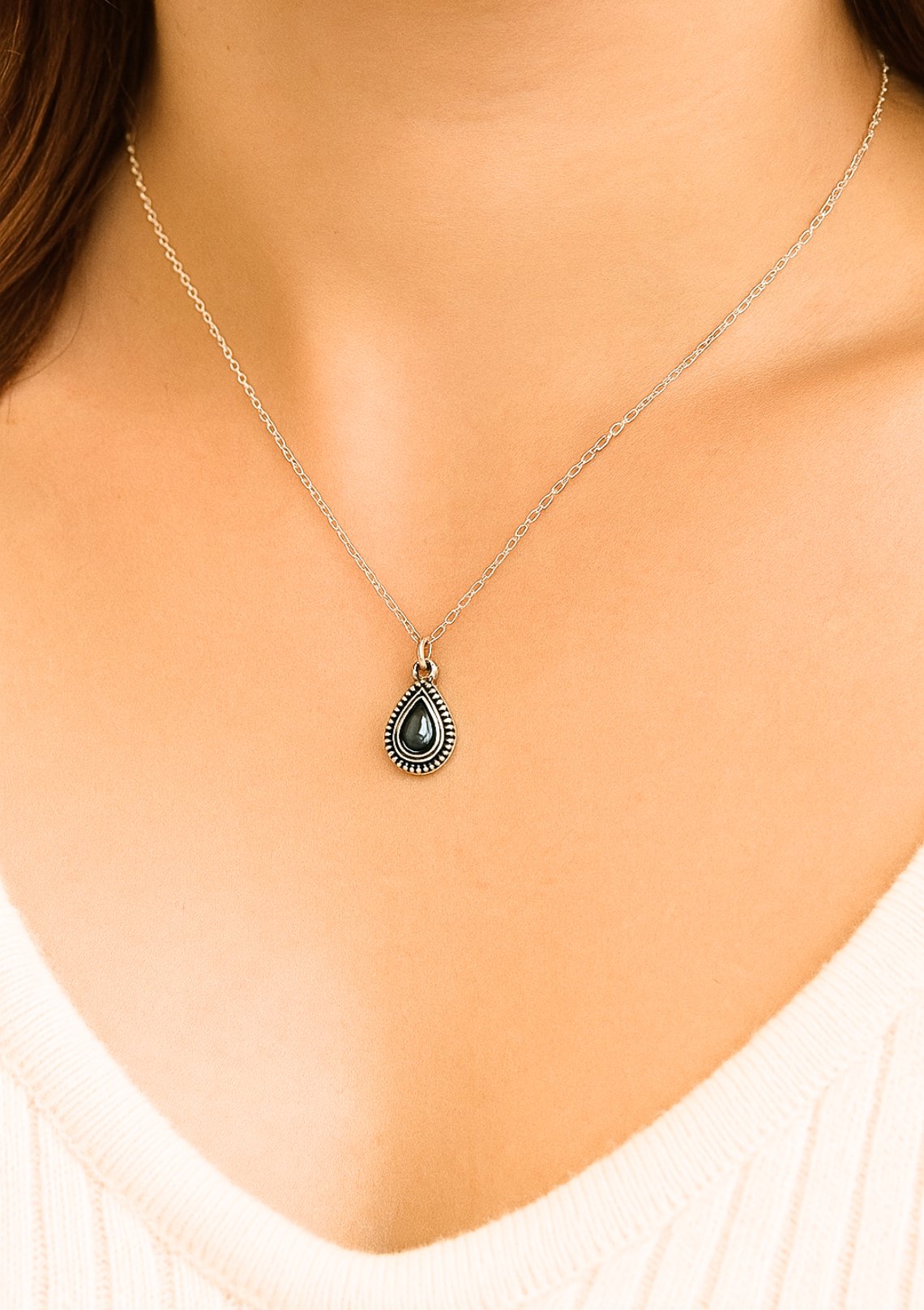 a woman chest wearing a sterling silver teardrop necklace