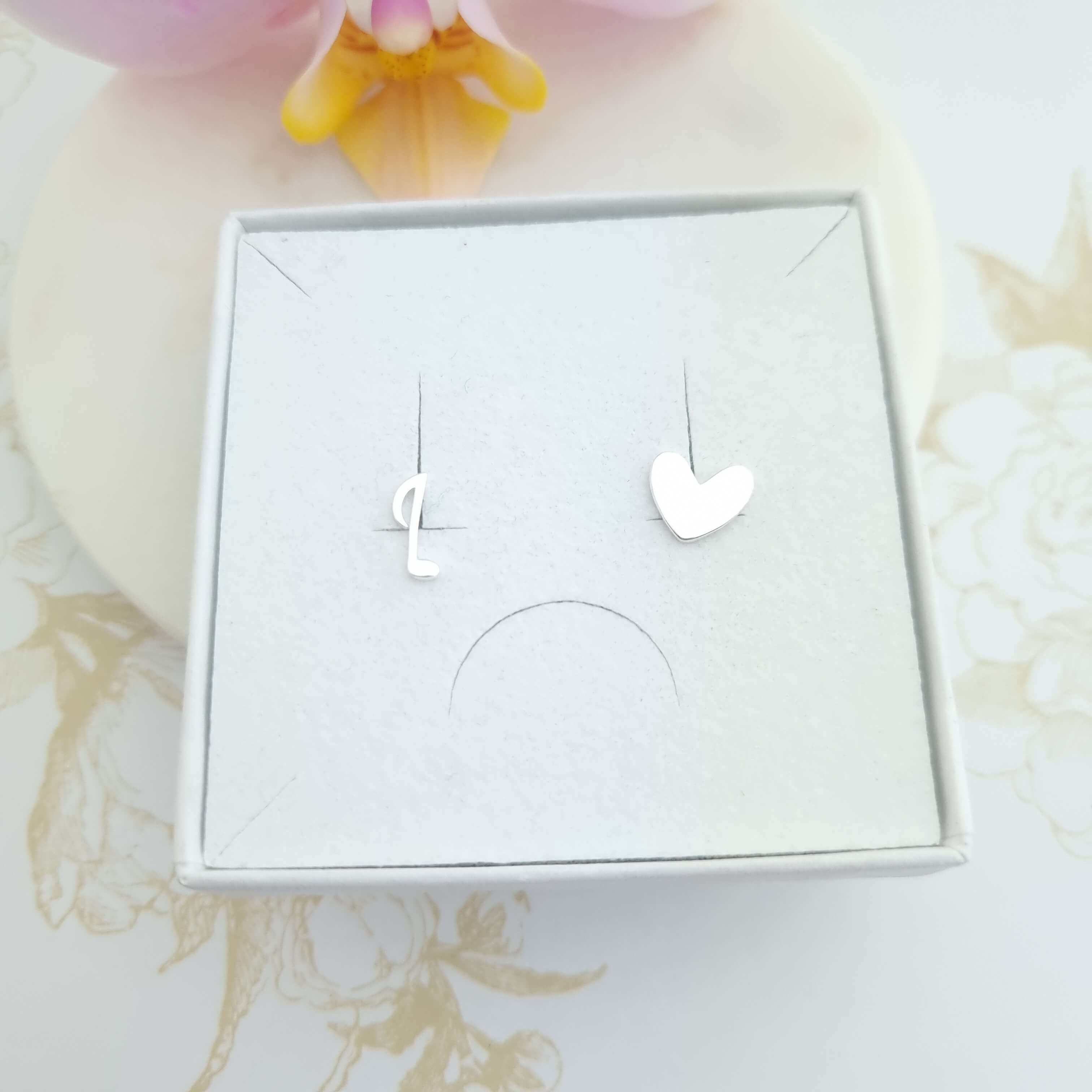 mismatched heart and music note stud earrings in sterling silver presented in a gift box