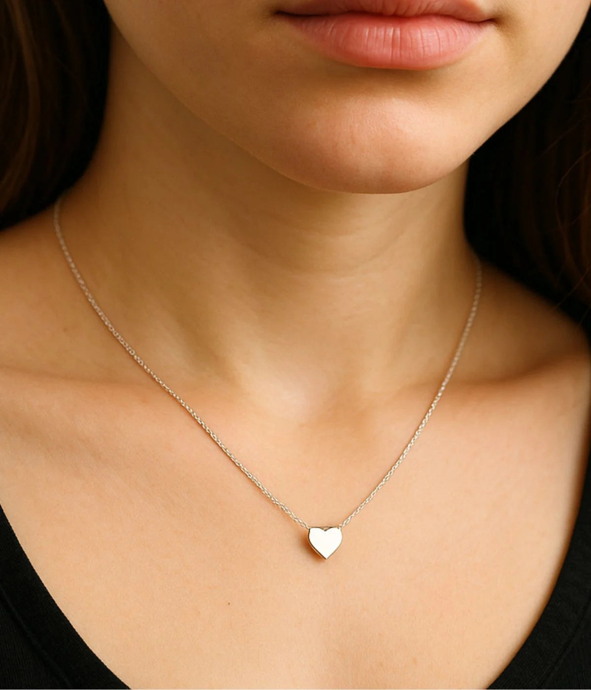 a closeup woman neck wearing a heart necklace
