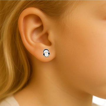 an child's ear with a penguin earrings