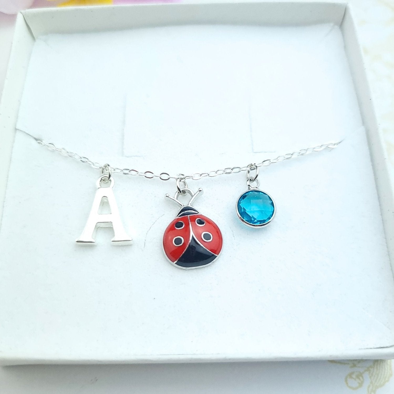 silver bracelet with ladybug, initial and birthstone