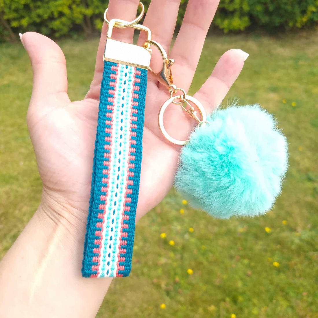 wrist lanyard in teal and green with pom pom