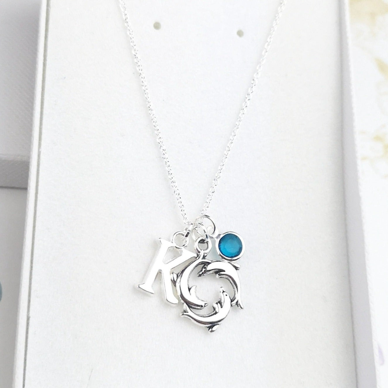 Dolphin sterling silver necklace with initial and birthstone in a gift box